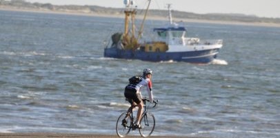 racefietser met op de achtergrond een schip